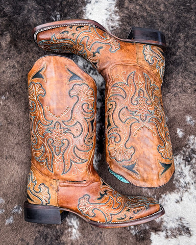 The Saddleback Shadow Corral Boots displayed on cowhide.