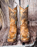 Front view of the Sandstone Stallion Corral Boots with a wood backdrop.