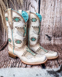Side view of the Feathered Frontier Corral Boots with a wood backdrop.