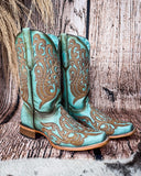 Side view of the Honey Dust Trailblazer Corral Boots with a wood backdrop.