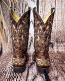 Back view of the Desert Blossom Corral Boots with a wood backdrop.