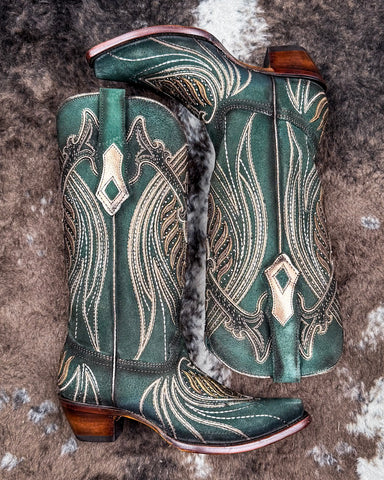 The Mystic Pine Corral Boots displayed on cowhide.