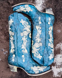 The Navy Blossom Corral Boots displayed on cowhide.