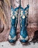 Front view of the Navy Blossom Corral Boots with a wood backdrop.