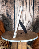 Side view of the Myra Bag - Tumbleweed Trail Photo Frame in Black and White on a wood background.