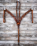The Turquoise Sunflower Tooled Breast Collar and Single Ear Headstall displayed on a wood backdrop.