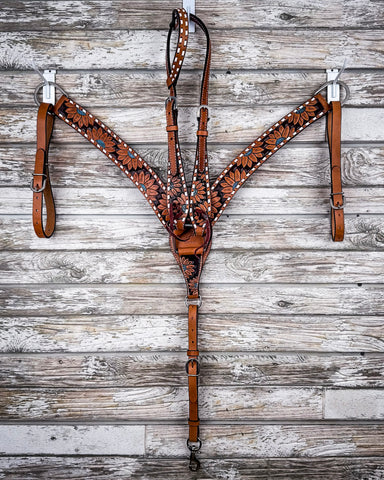 The Turquoise Sunflower Tooled Breast Collar and Single Ear Headstall displayed on a wood backdrop.