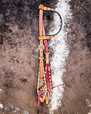 Side view of the Turquoise Sunflower Tooled Single Ear Headstall displayed on cowhide.