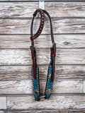 The Turquoise Wash Bull Coin Single ear Headstall displayed on a wood backdrop.
