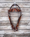 The Turquoise Sunflower Tooled Browband Headstall displayed on a wood backdrop.