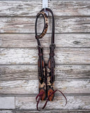 The Peppered Hair On Hide Single Ear Headstall displayed on a wood backdrop.