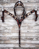 The Peppered Hair On Hide Breast Collar and Brow Band Headstall displayed on a wood backdrop.