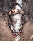 Zoom in of the Peppered Hair On Hide Single Ear Headstall displayed on cowhide showing design.