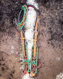 Painted Cactus One Ear Headstall displayed on cowhide.