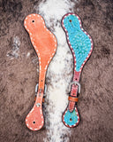 Turquoise Collection Ladies Spur Straps displayed on cowhide.