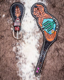 Beaded Cactus Ladies Spur Straps displayed on cowhide.