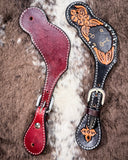 Signature Western Ladies Spur Straps displayed on cowhide.