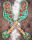 Painted Cactus Ladies Spur Straps displayed on cowhide.