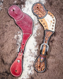 Cowhide and Brass Accent Ladies Spur Straps displayed on cowhide.