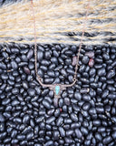 The Gilded Longhorn Fashion Necklace displayed on pebble and wheat background