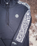 Sleeve close up of Canyon Ladies Hooey Hoodie displayed on cowhide background.