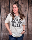Wild As Hell Graphic Tee modeled and styled Infront of wood backdrop.