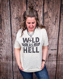 Wild As Hell Graphic Tee modeled and styled Infront of wood backdrop.