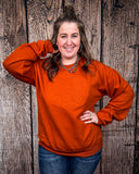 Model wearing the Pumpkin Spice Pullover in front of a wood backdrop.