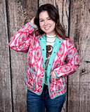 The Brynella Aztec Jacket on a model in front of a wood backdrop.