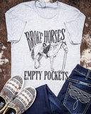 Broke Horses Empty Pockets Graphic Tee  displayed and styled on hide background.