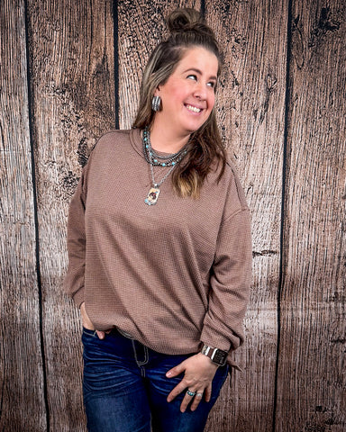 The Stillwater Tunic Top styled and modeled on a women in front of wood backdrop.