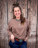 The Stillwater Tunic Top styled and modeled on a women in front of wood backdrop.
