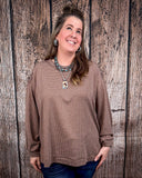 The Stillwater Tunic Top styled and modeled on a women in front of wood backdrop.