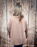 The Stillwater Tunic Top styled and modeled on a women in front of wood backdrop.