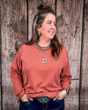 The Stillwater Tunic Top in color Rust being styled and modeled on women in front of wood backdrop.
