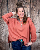 The Stillwater Tunic Top in color Rust being styled and modeled on women in front of wood backdrop.