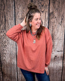 The Stillwater Tunic Top in color Rust being styled and modeled on women in front of wood backdrop.
