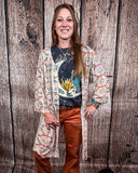 Acoma Aztec Duster being styles and worn by a women in front if wood background.