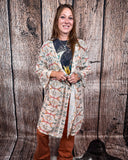 Acoma Aztec Duster being styles and worn by a women in front if wood background.