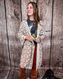 Acoma Aztec Duster being styles and worn by a women in front if wood background.