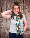 The Sloan Top in Pearl Grey being styled and modeled on a women in front of wood background.