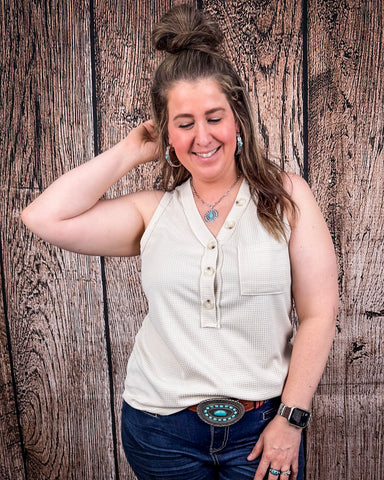 The Lanie Tank in Oatmeal being styled with jeans and modeled on a women in front of wood backdrop.