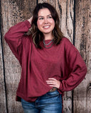 The Stillwater Tunic Top being styled  and modeled by women in front of wooden backdrop.