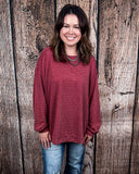 The Stillwater Tunic Top being styled  and modeled by women in front of wooden backdrop.