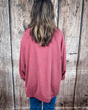 The Stillwater Tunic Top being styled and modeled by women in front of wooden backdrop.