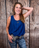 The Caldera Tank in Navy being styled and worn by a women in front of wood background.
