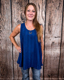 The Caldera Tank in Navy being styled and worn by a women in front of wood background.