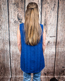The Caldera Tank in Navy being styled and worn by a women in front of wood background.