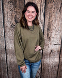 The Stillwater Tunic Top in Olive being styled and modeled on women in front of wooden backdrop.