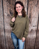 The Stillwater Tunic Top in Olive being styled and modeled on women in front of wooden backdrop.